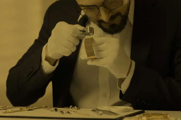 Prüfung von Goldschmuck mit der Lupe durch einen Experten in Berlin.